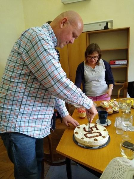 Oslavenec se odvážně pouští do krájení dortu (foto: Eva Uzlová, Knihovna Národního archivu)